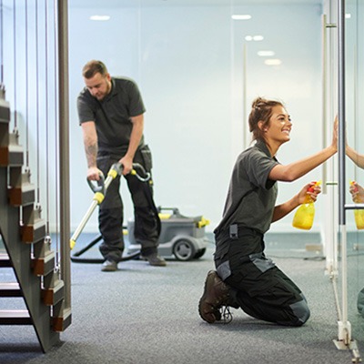 Uniformed janitorial workers cleaning and vacuuming