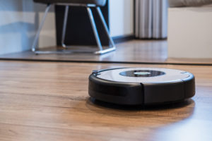 Robotic vacuum cleaner working on laminate wooden floor