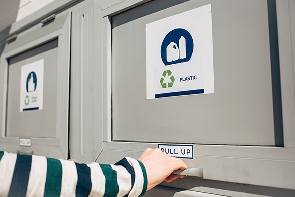 Hand opening a trash chute door